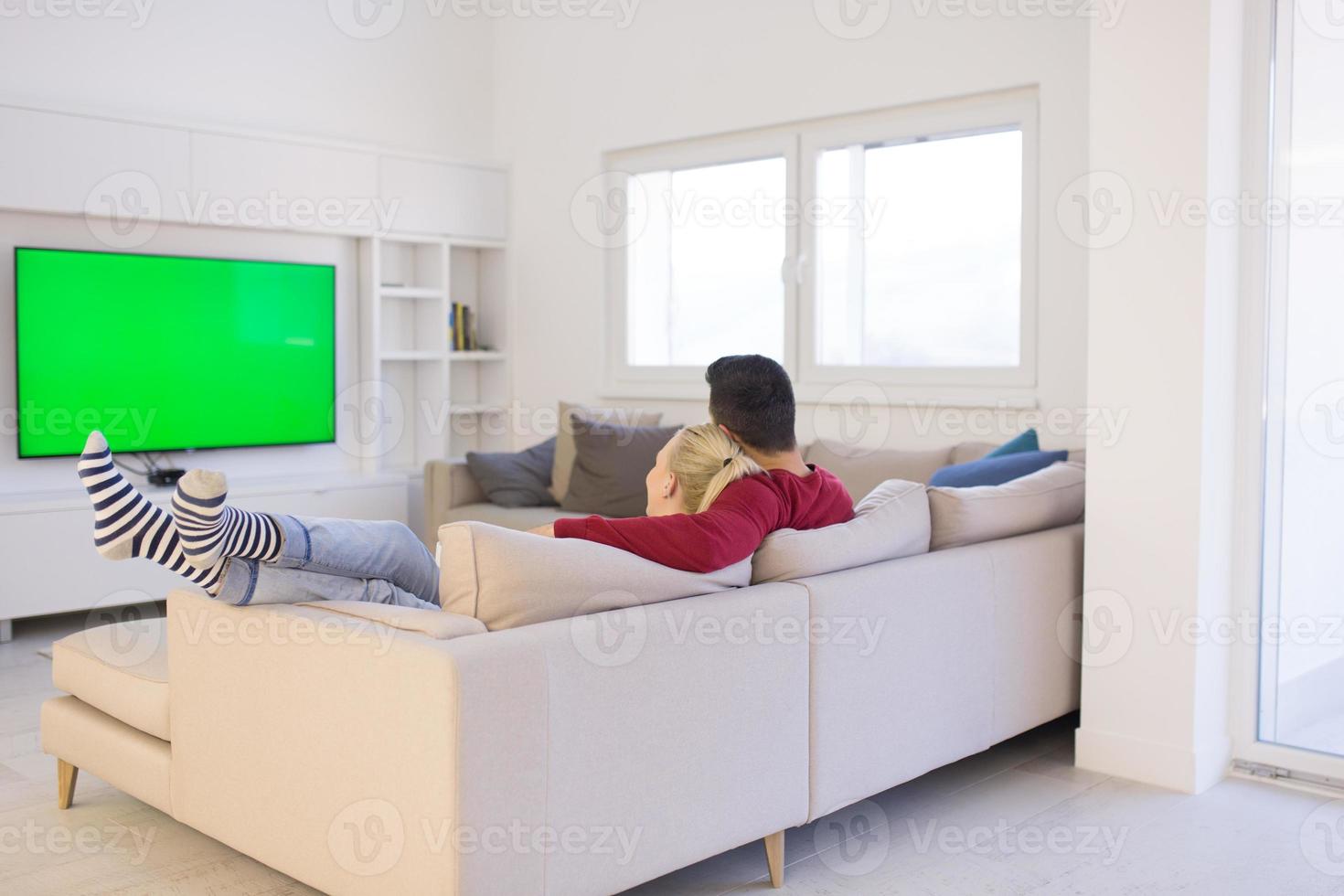 jeune couple sur le canapé devant la télévision photo