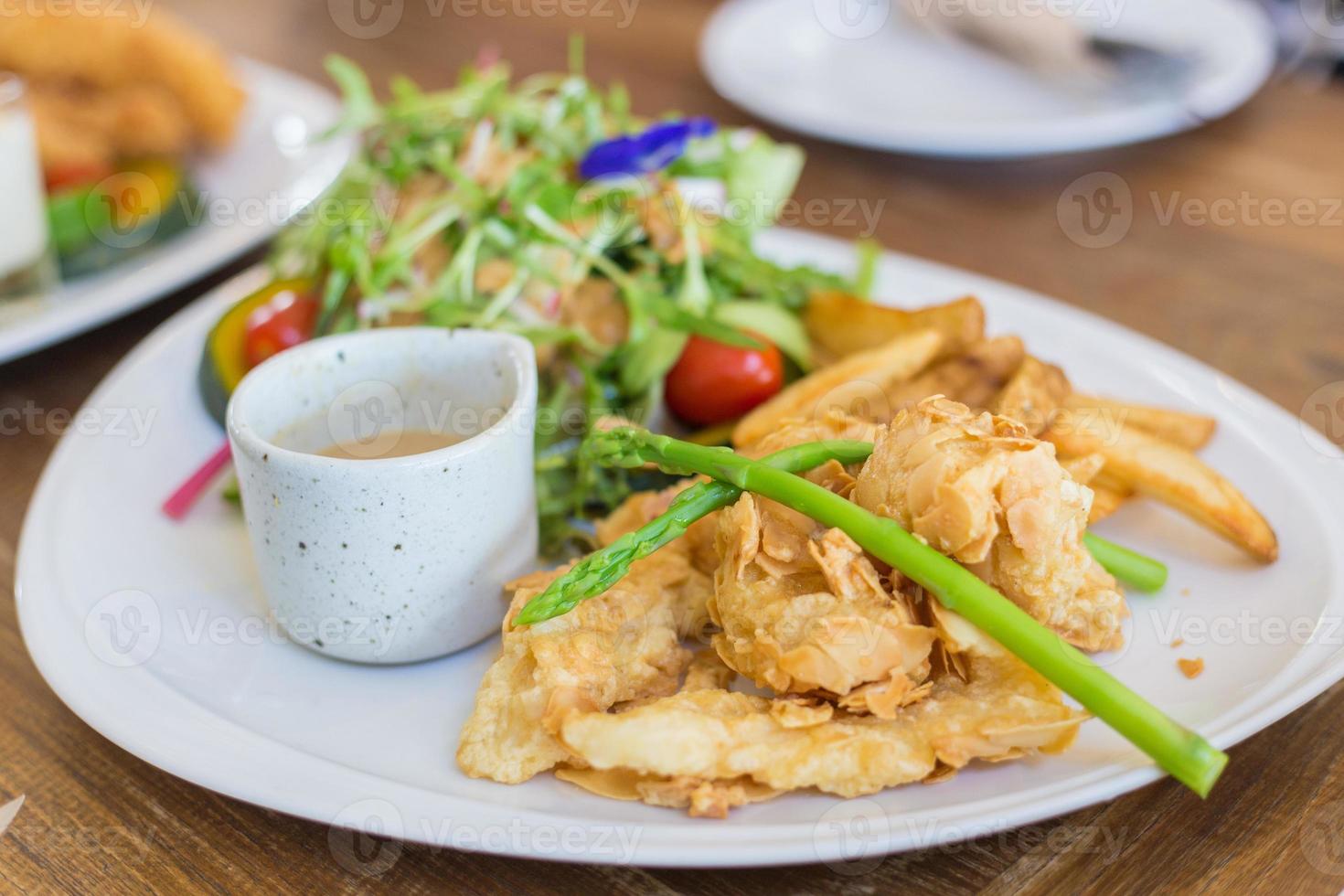 steak de poisson croustillant aux amandes poisson de mer frit aux amandes croustillant avec des salades fraîches est un aliment sain et délicieux. photo