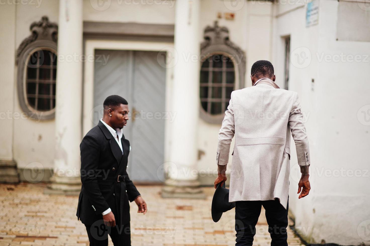 deux hommes noirs de la mode. portrait à la mode de modèles masculins afro-américains. porter un costume, un manteau et un chapeau. photo