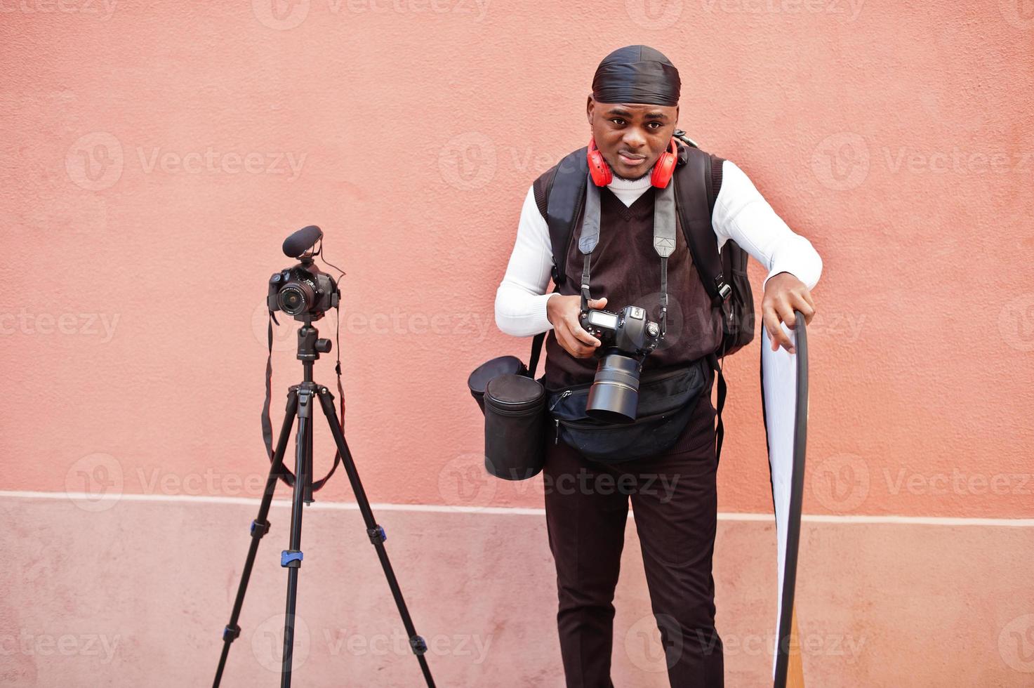 jeune vidéaste afro-américain professionnel tenant une caméra  professionnelle avec un équipement de trépied pro. caméraman afro portant  du duraq noir faisant des vidéos. 11012703 Photo de stock chez Vecteezy