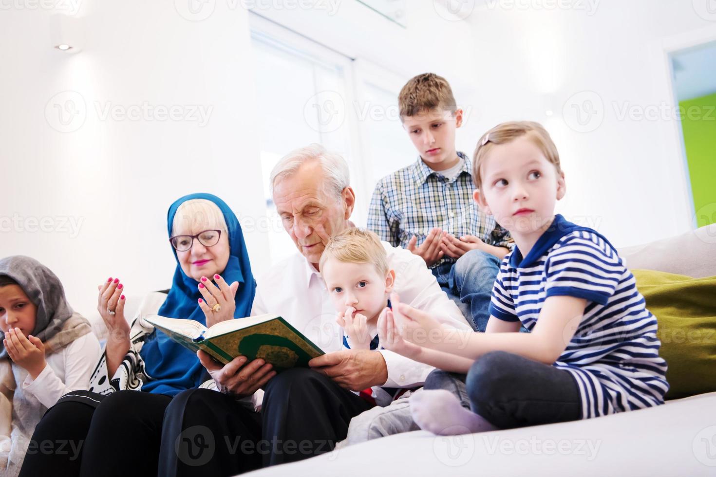 grands-parents musulmans modernes avec petits-enfants lisant le coran photo