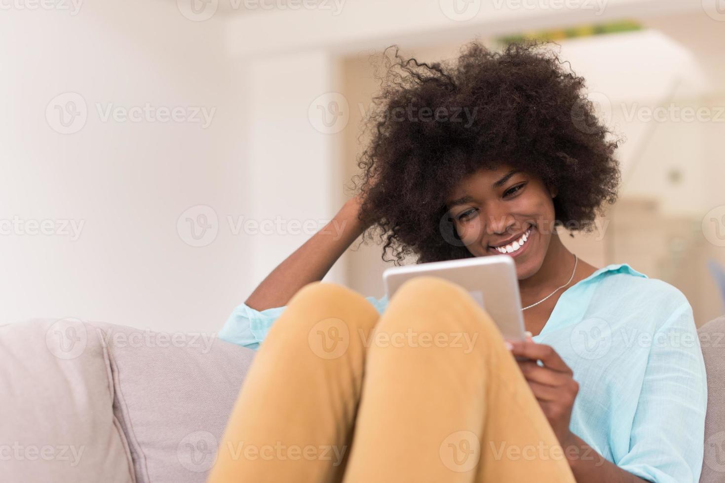 femme afro-américaine à la maison à l'aide d'une tablette numérique photo