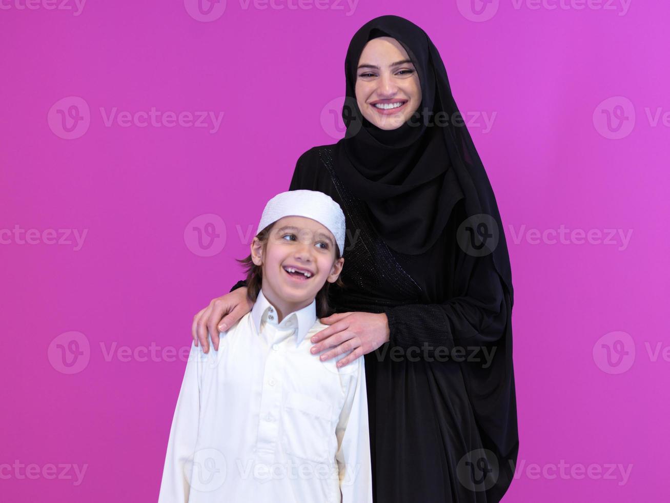 portrait d'une mère musulmane et de son fils sur fond rose photo