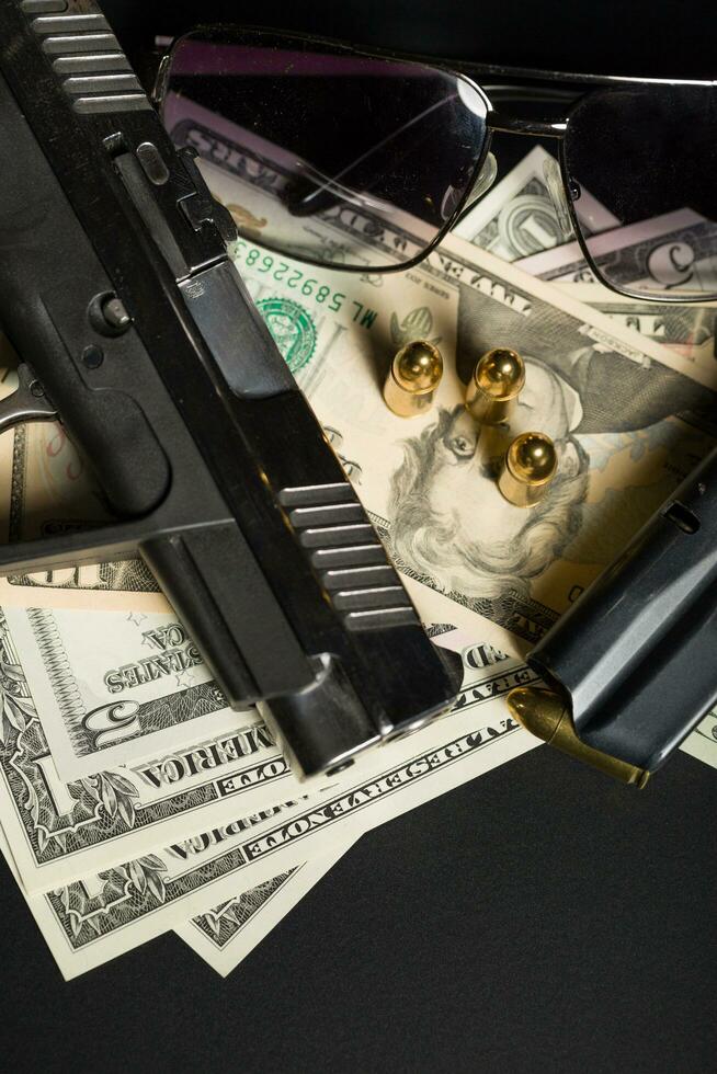 pistolet avec balle sur les billets en dollars américains photo