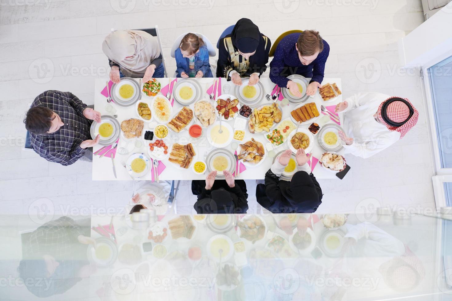 famille musulmane traditionnelle priant avant le dîner iftar vue de dessus photo