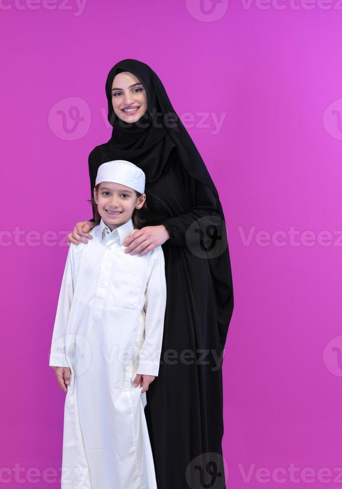 portrait d'une mère musulmane et de son fils sur fond rose photo