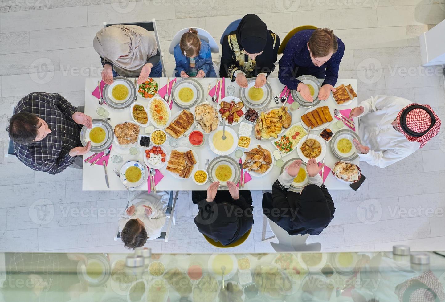 vue de dessus de la famille musulmane faisant de l'iftar dua pour rompre le jeûne pendant le ramadan. photo