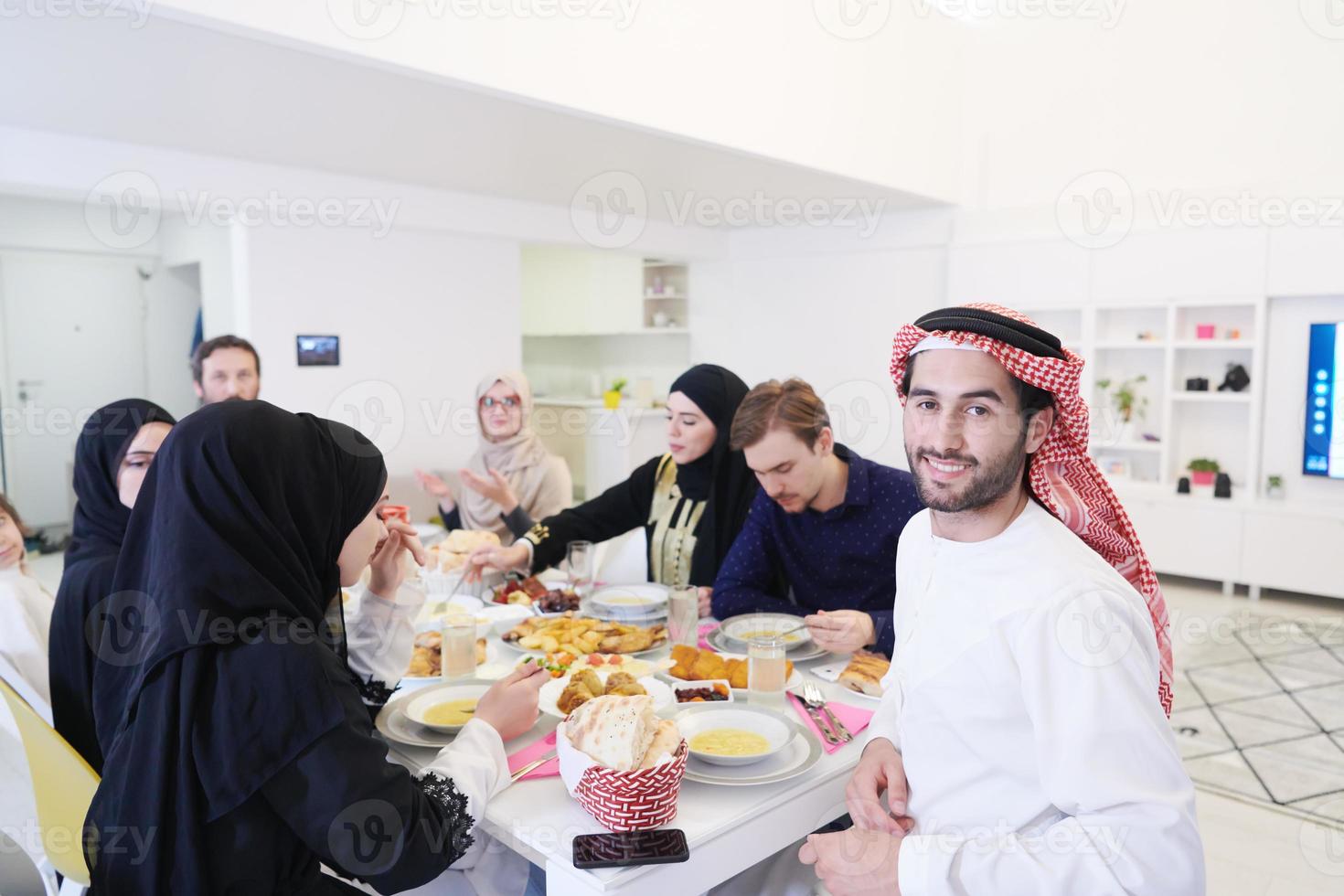 jeune homme arabe en train de dîner iftar avec une famille musulmane photo