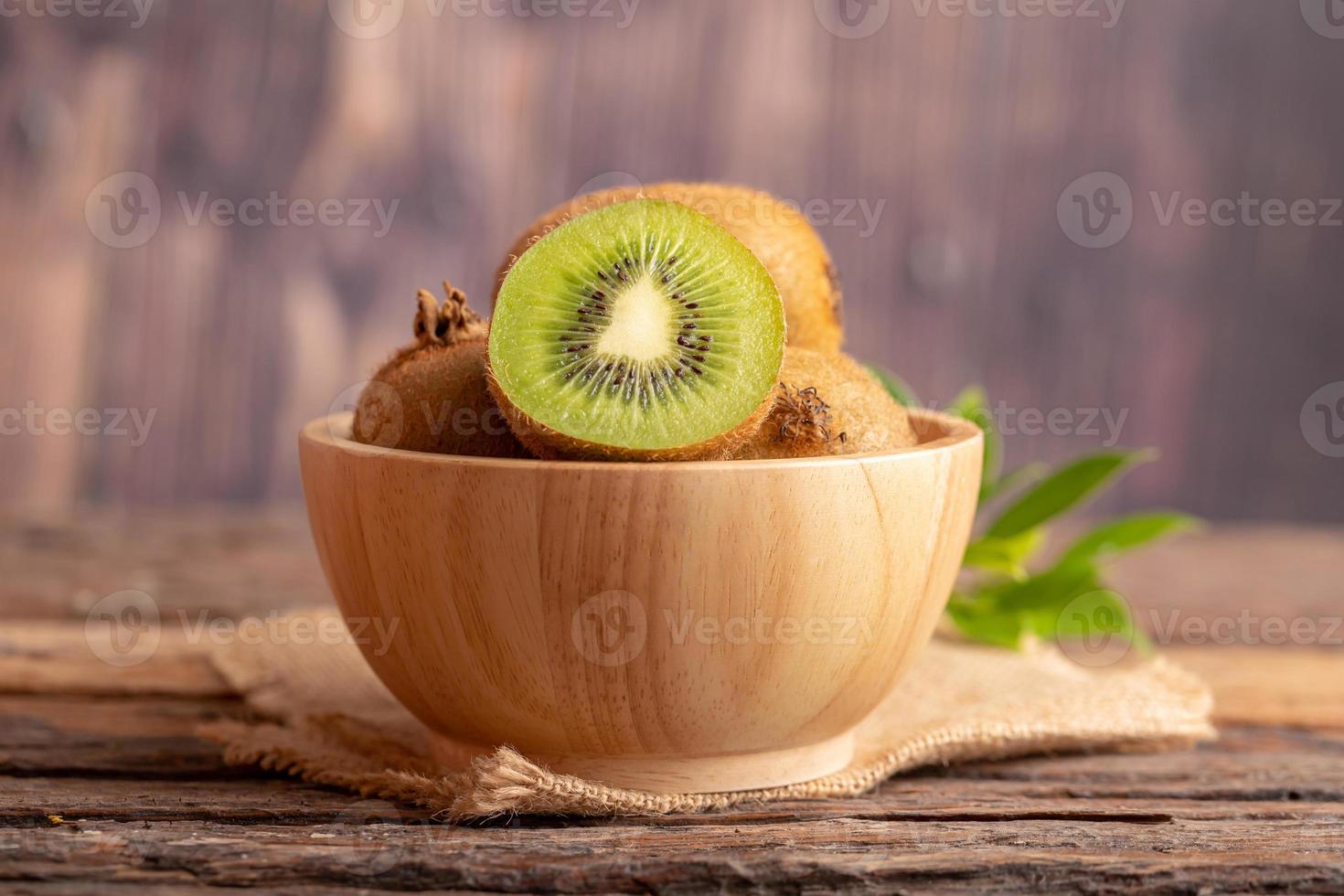 une moitié de kiwi vert frais dans un bol en bois photo