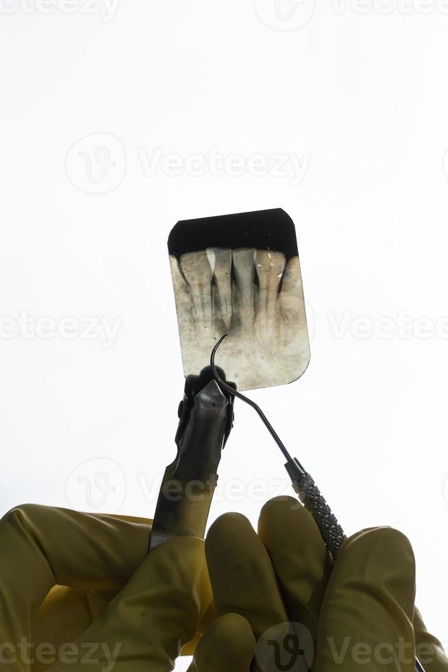 Dentiste tenant une radiographie dentaire découpée isolé sur fond blanc photo