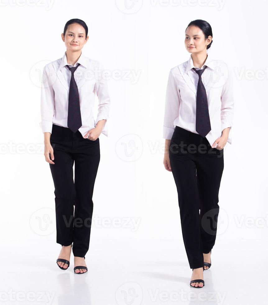 pleine longueur 20s jeune femme de race mixte employée de barman, marchant vers l'avant gauche droite, porter une cravate et une chemise formelles. les stands féminins de bureau ressentent du stress sur fond blanc isolé photo