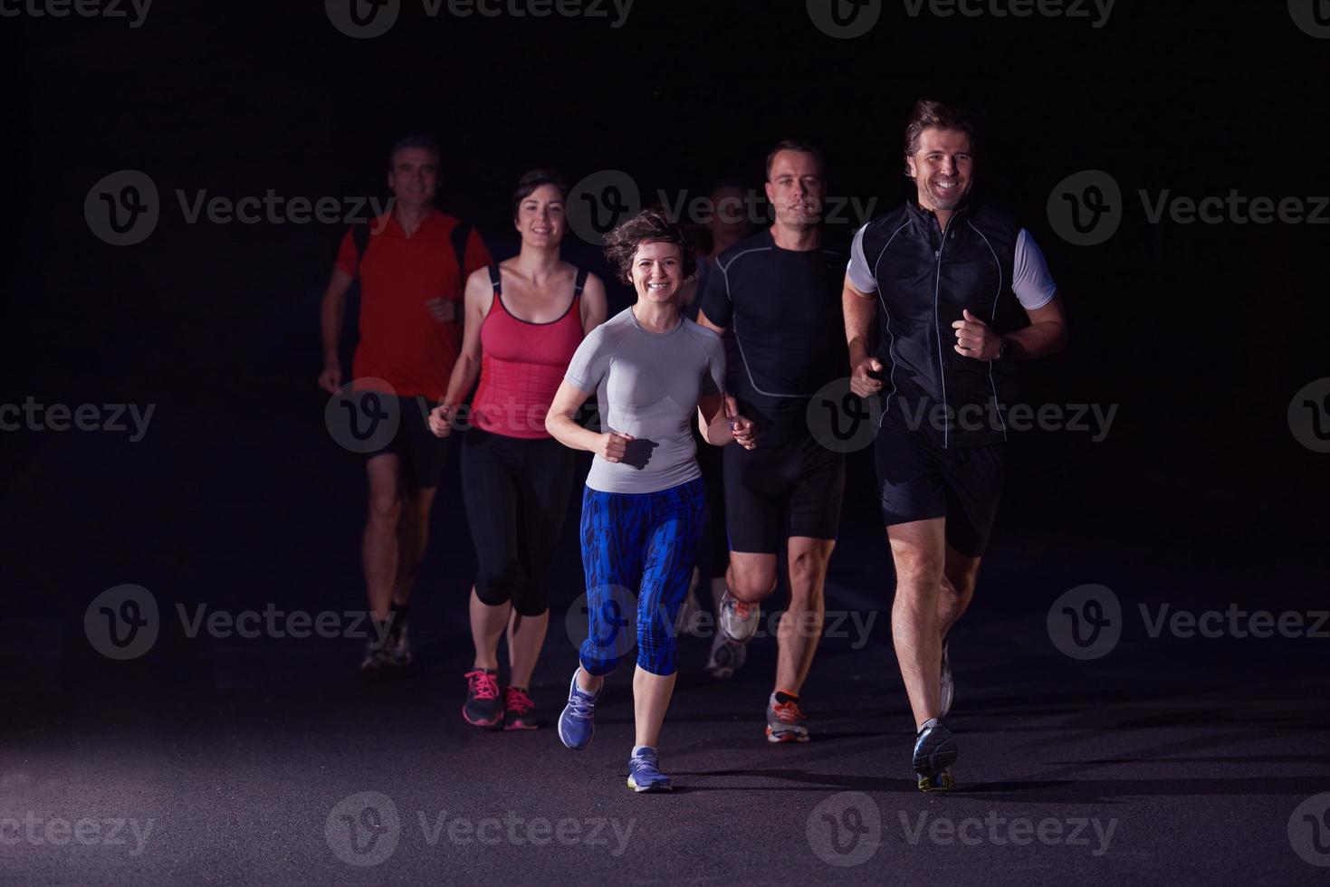 groupe de personnes faisant du jogging la nuit photo