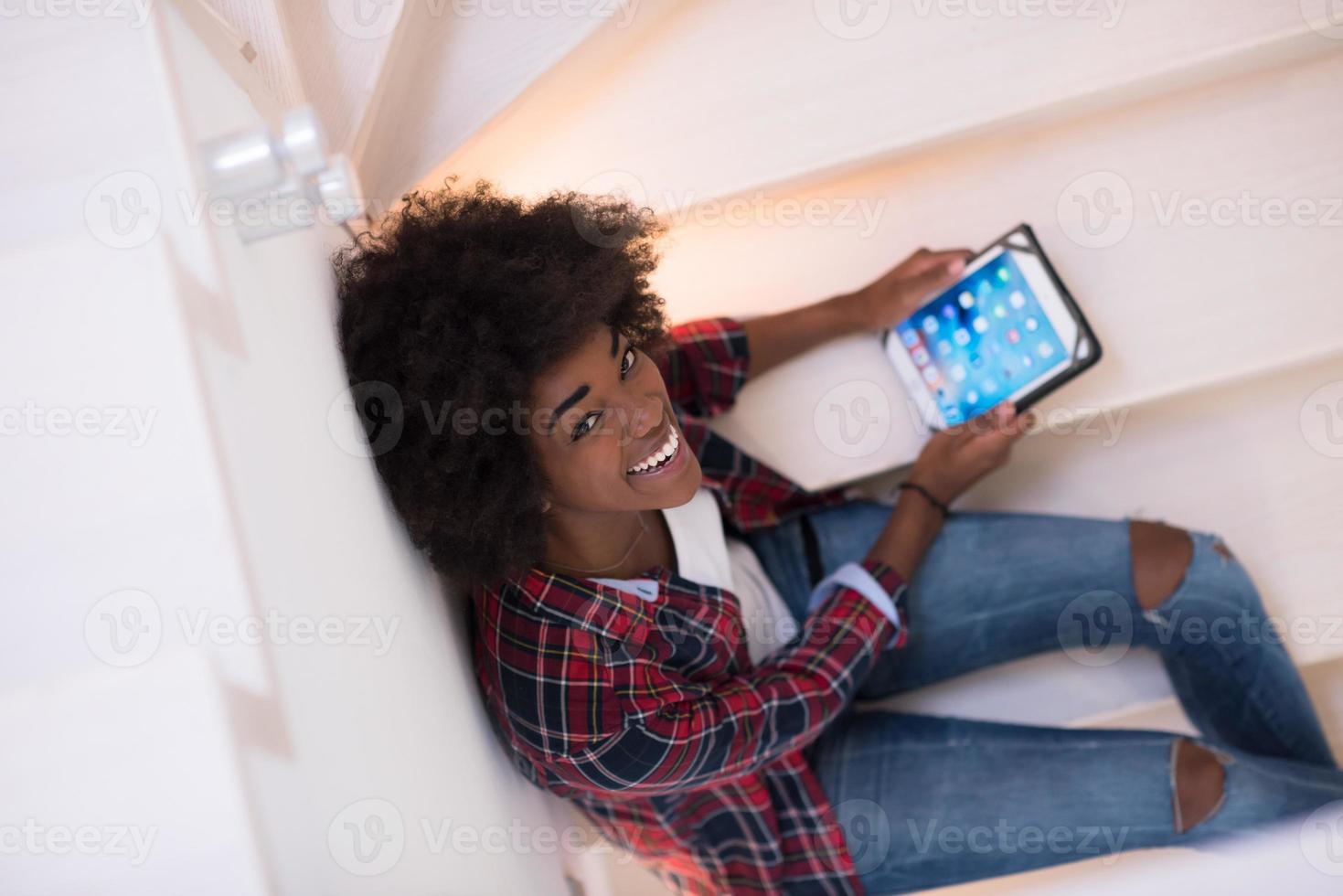 femme noire à l'aide de sa tablette électronique photo