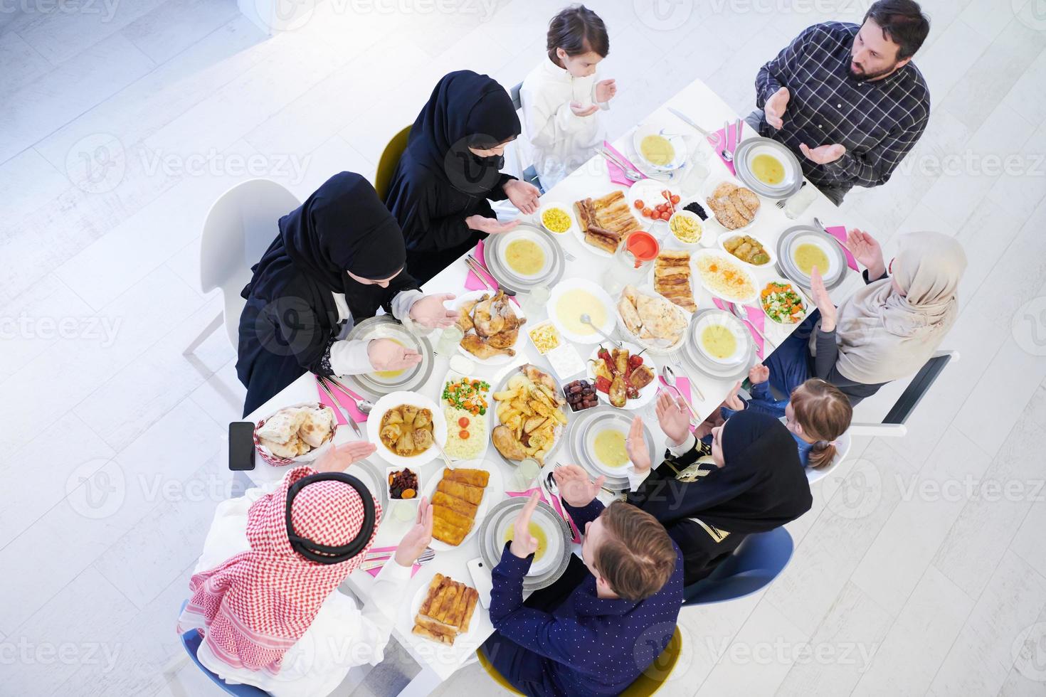 famille musulmane traditionnelle priant avant le dîner de l'iftar photo