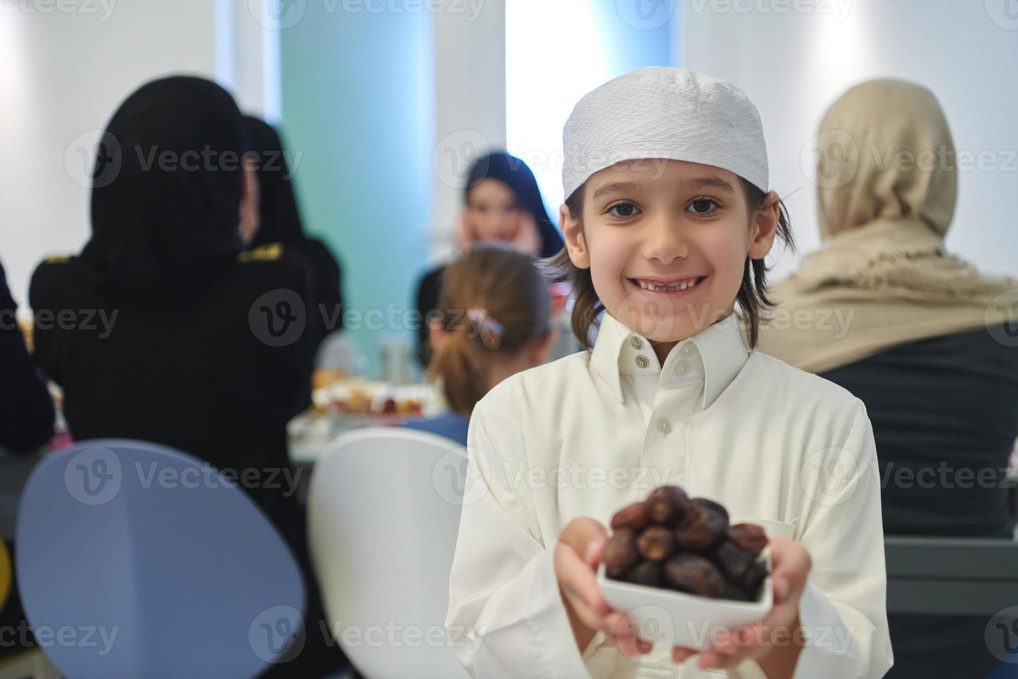 enfant arabe dans les vêtements traditionnels pendant l'iftar photo