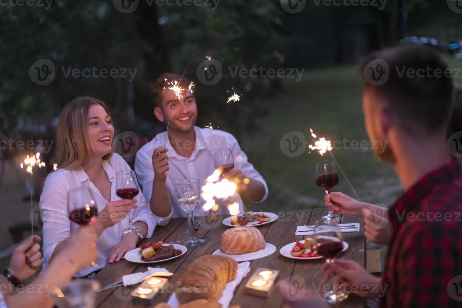 amis portant un verre de vin rouge tout en pique-nique dîner français en plein air photo