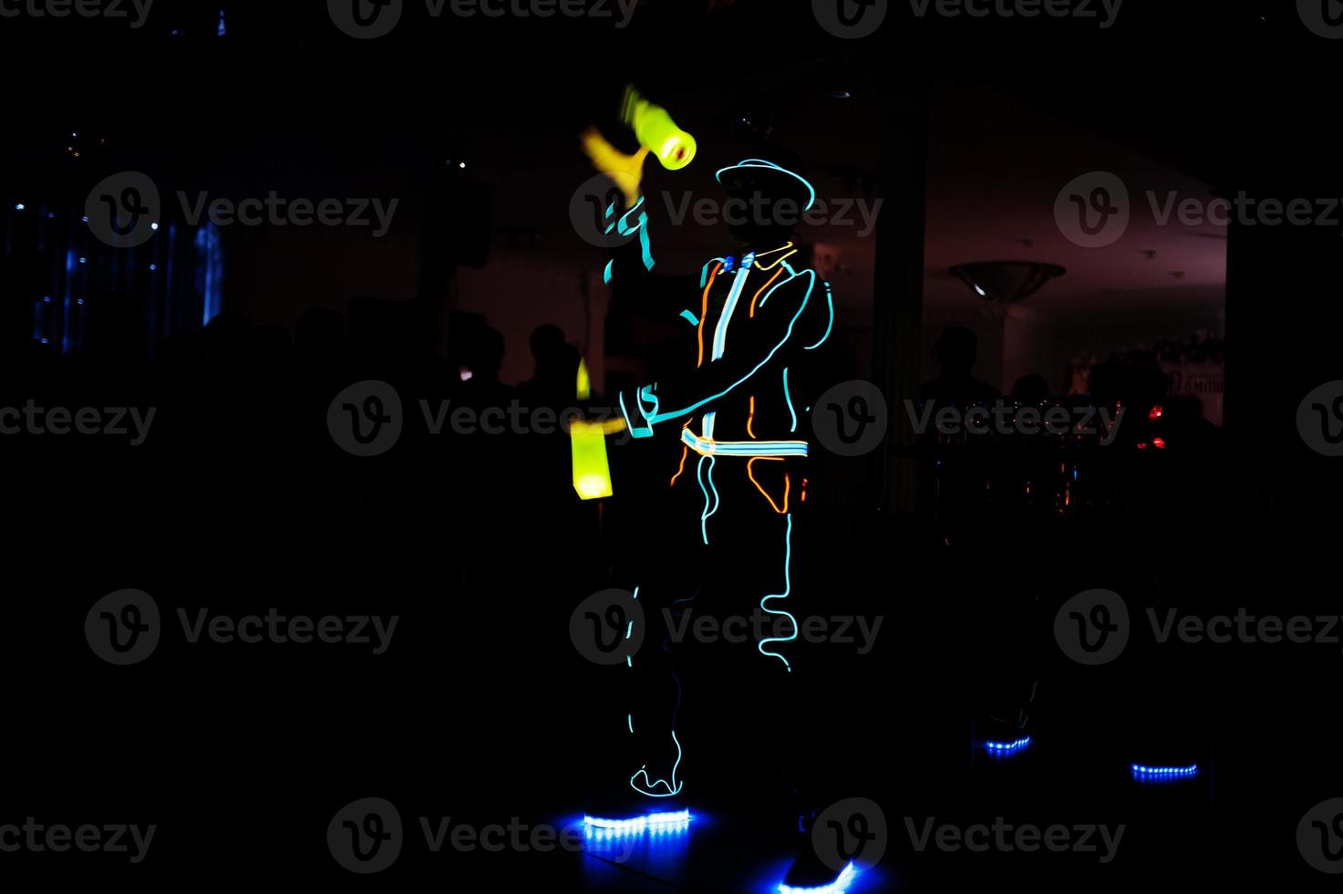 barman professionnel et spectacle de lumière led. silhouette de barman moderne secouant la boisson au bar à cocktails de nuit. photo