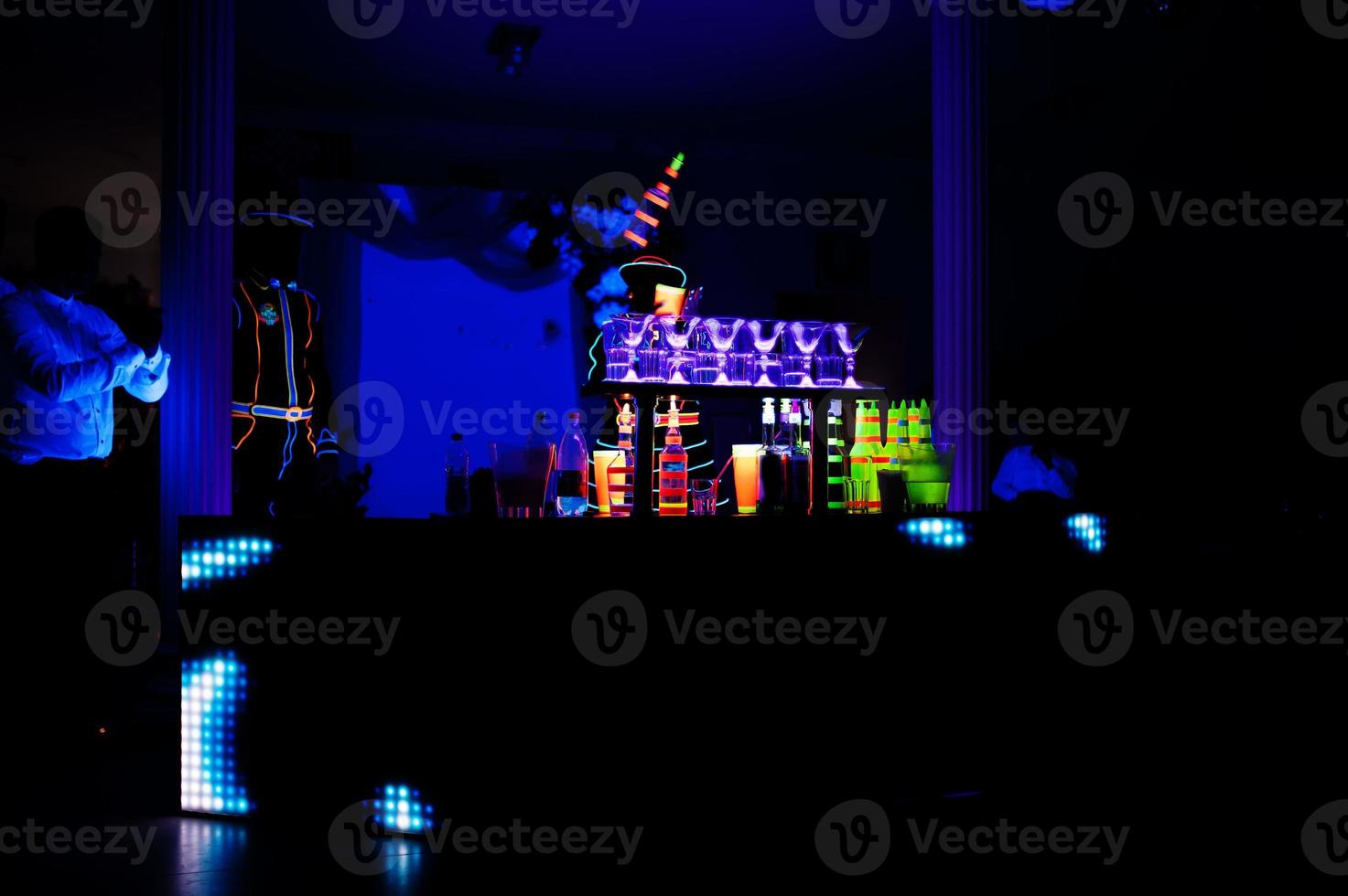 barman professionnel et spectacle de lumière led. silhouette de barman moderne secouant la boisson au bar à cocktails de nuit. photo