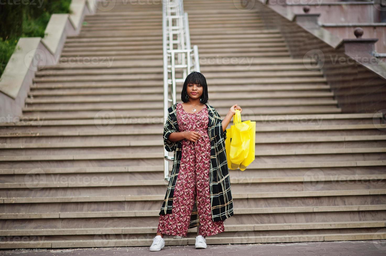 belle femme afro-américaine avec symbole de recyclage de sacs écologiques en tissu jaune. photo