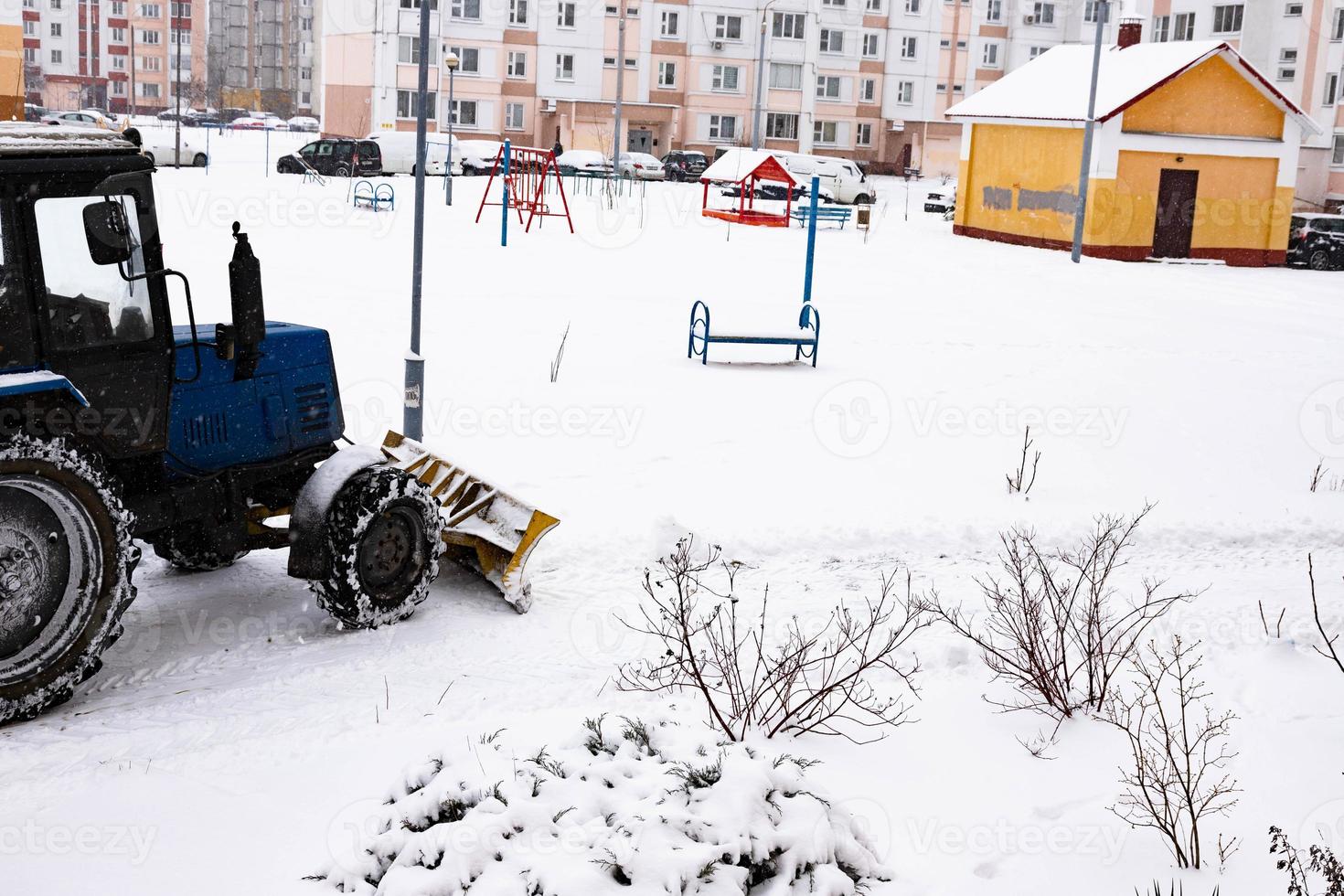 le tracteur dégage la route de la neige en hiver lors d'une chute de neige. photo