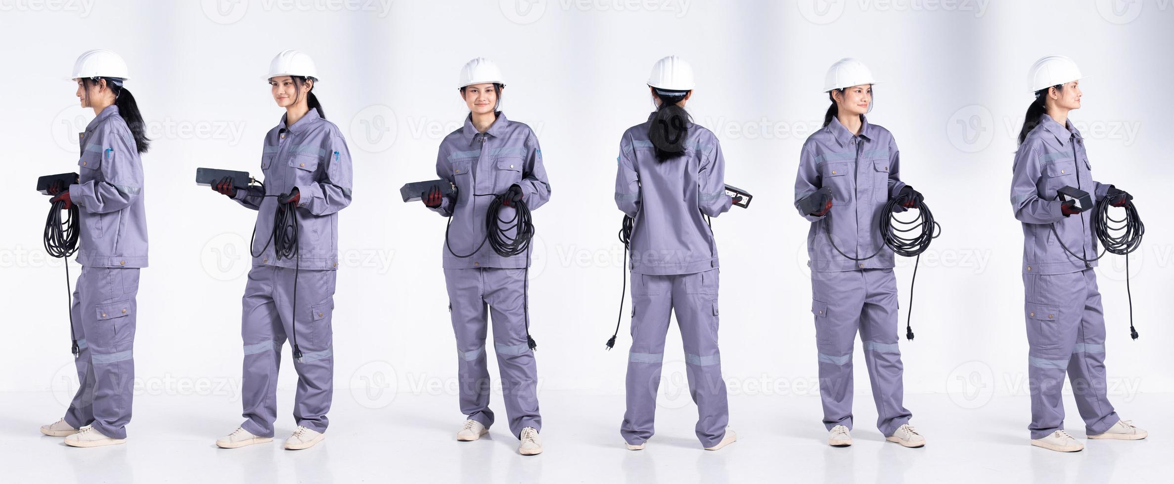 pleine longueur 20s jeune femme électricienne ingénieur de course mixte, 360 vue arrière arrière avant, porter un uniforme gris. Femme entrepreneur tenir le câble de prise électrique sourire heureux sur fond blanc isolé photo