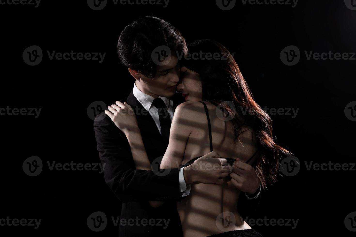 un jeune couple s'embrasse avec amour, un homme d'affaires essaie de dénouer le soutien-gorge de sa petite amie photo