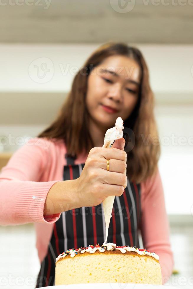 une jeune femme adulte asiatique apprend à faire de la boulangerie en cuisinant des gâteaux en ligne dans la cuisine. vidéo de la mère féminine à la classe du cyberespace sur ordinateur portable en tant que blogueur contenu des médias sociaux et apprentissage en continu, espace de copie photo