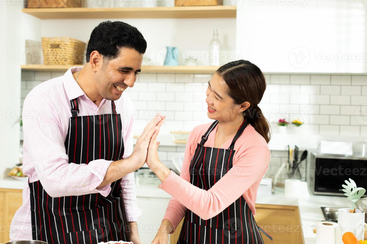 une femme asiatique et un homme arabe en tant que jeune couple adulte apprennent à cuisiner en ligne un gâteau de cuisson à la boulangerie. vidéo familiale diversifiée à la classe de cyberespace sur ordinateur portable en tant que blogueur médias sociaux ensemble, espace de copie photo