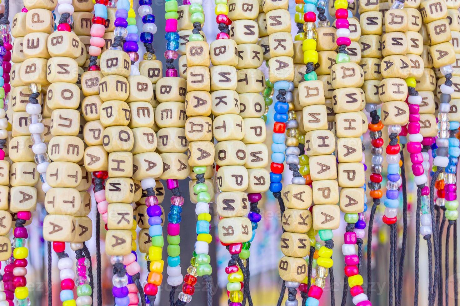 bracelets faits à la main avec des noms russes dans une boutique de souvenirs. fond coloré photo