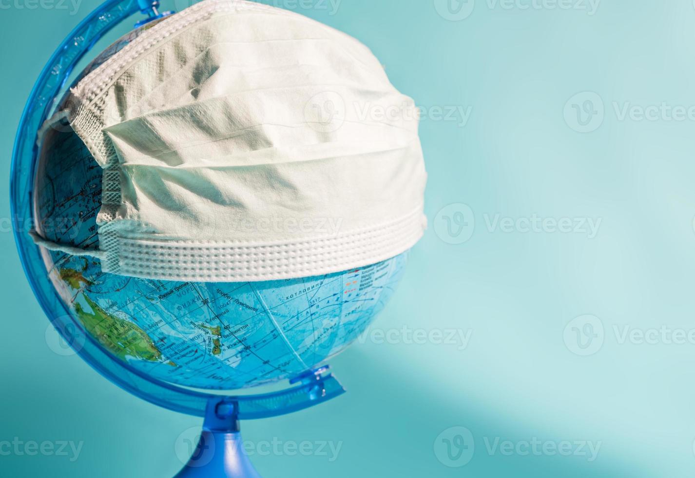 épidémie de coronavirus. pandémie mondiale. globe en masque de médecine sur fond bleu photo
