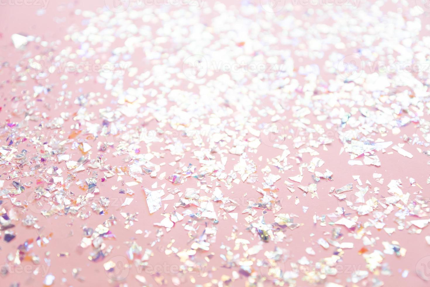 les confettis de perles scintillent sur fond de vacances rose. toile de fond festive d'étincelles pour anniversaire, carnaval photo