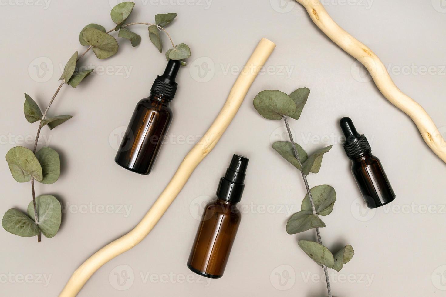 huile d'eucalyptus dans un flacon compte-gouttes en verre foncé avec extrait de plantes, soins de la peau et concept de médecine alternative, feuilles d'eucalyptus en arrière-plan photo