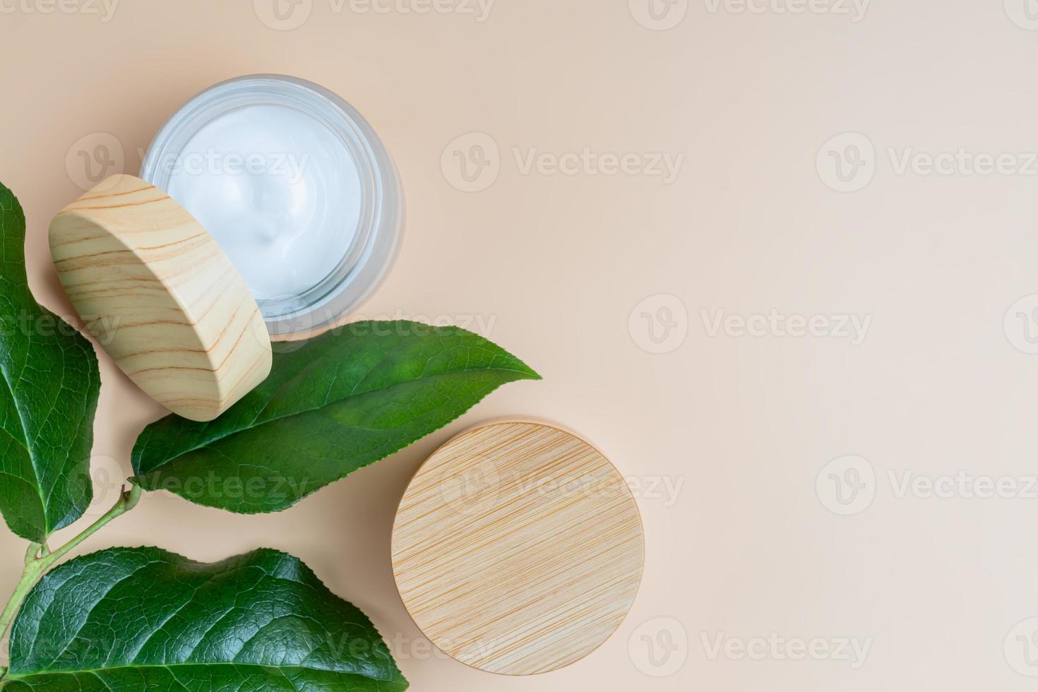 emballage cosmétique avec des feuilles vertes à base de plantes. ensemble de deux pots cosmétiques de crème ou de lotion sur fond beige. emballage vierge. concept de produit de spa de beauté naturelle. maquette. photo