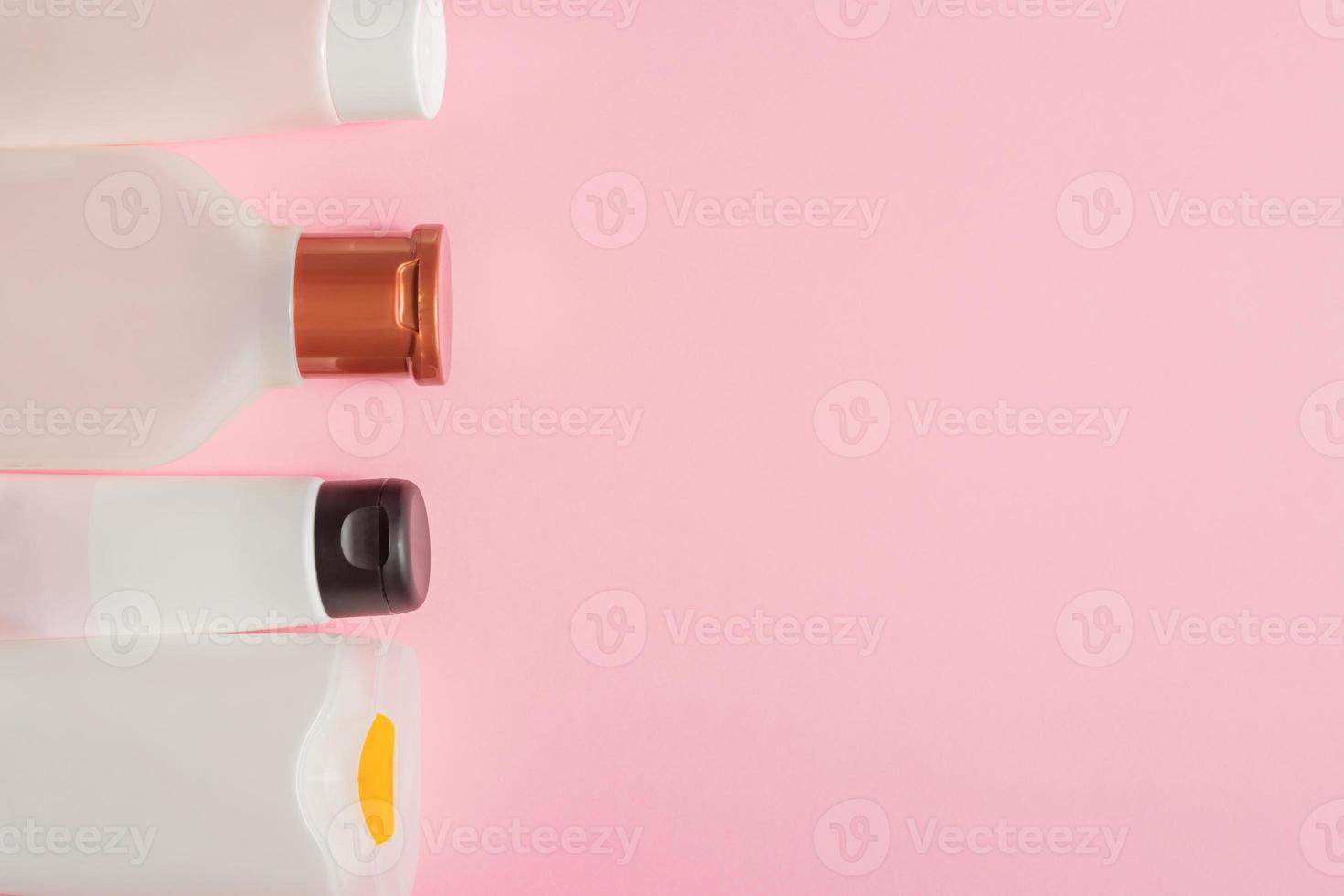 groupe de bouteilles de soins corporels en plastique. composition à plat avec des produits cosmétiques sur fond rose espace vide pour votre conception. ensemble de contenants cosmétiques blancs, vue de dessus photo