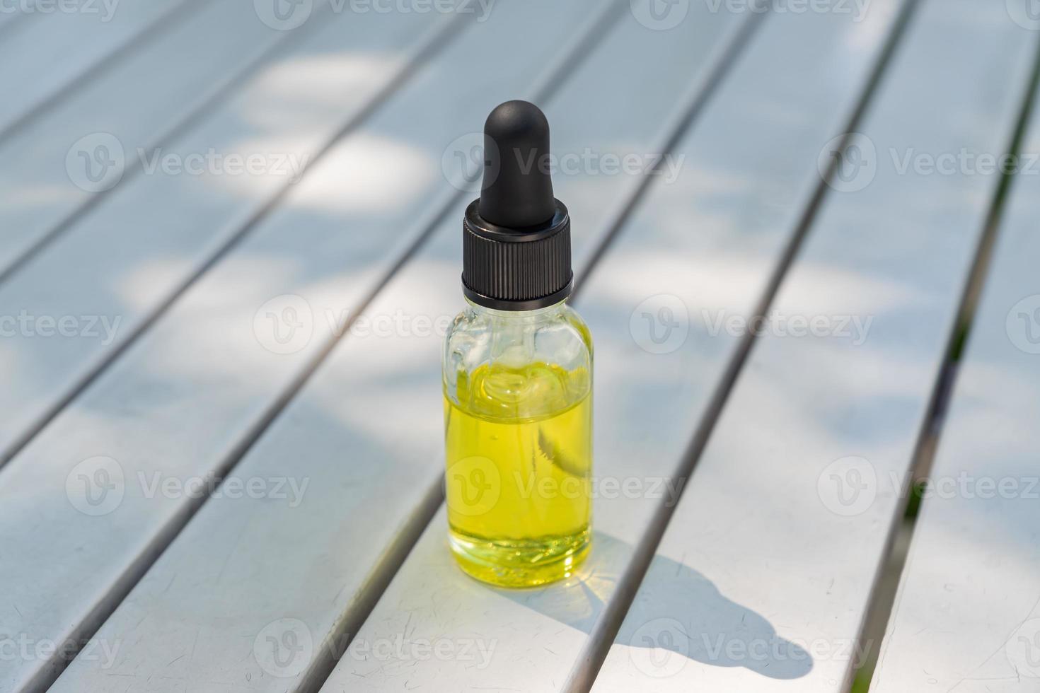 maquette de bouteille en verre compte-gouttes. Sérum de pipette cosmétique sur fond de bois blanc avec shdows et lumière dure photo