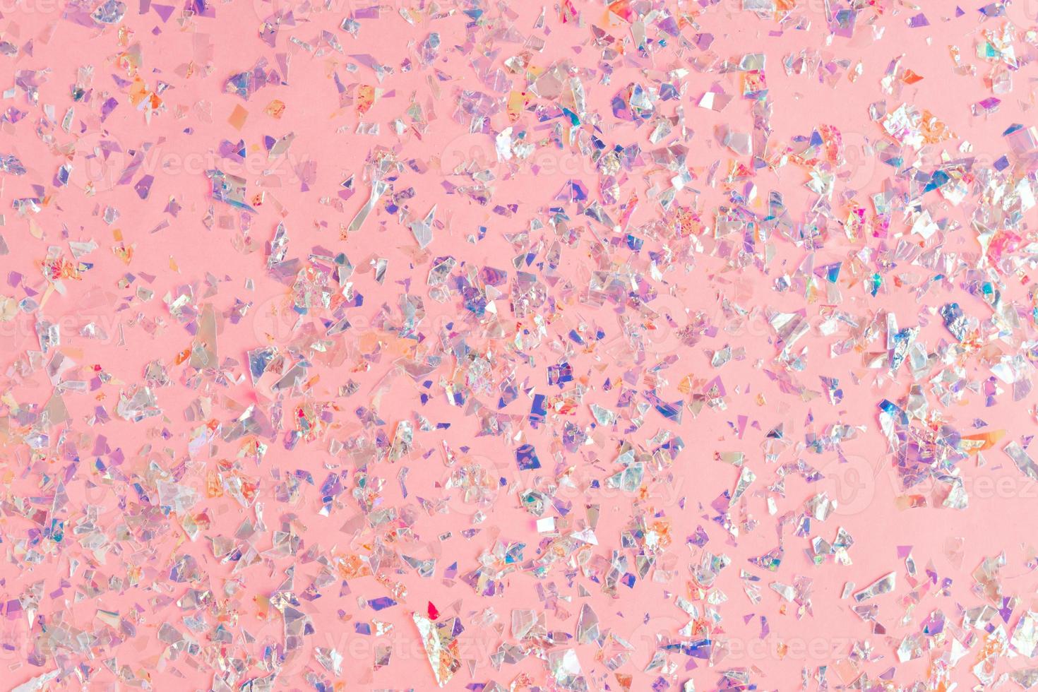 les confettis de perles scintillent sur fond de vacances rose. toile de fond festive d'étincelles pour anniversaire, carnaval photo