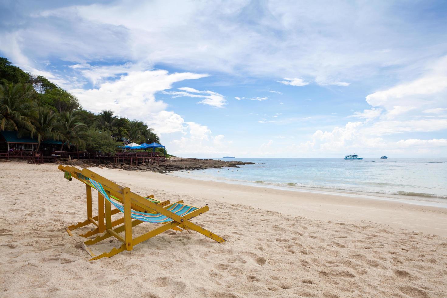 chaises de plage sur la plage de sable blanc avec ciel bleu nuageux photo