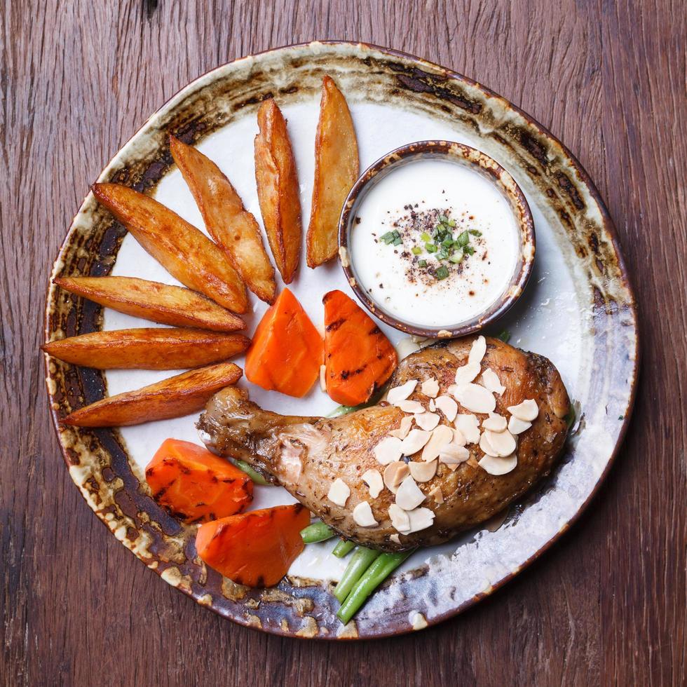 pilons de poulet frit avec frites, carotte sur assiette. photo