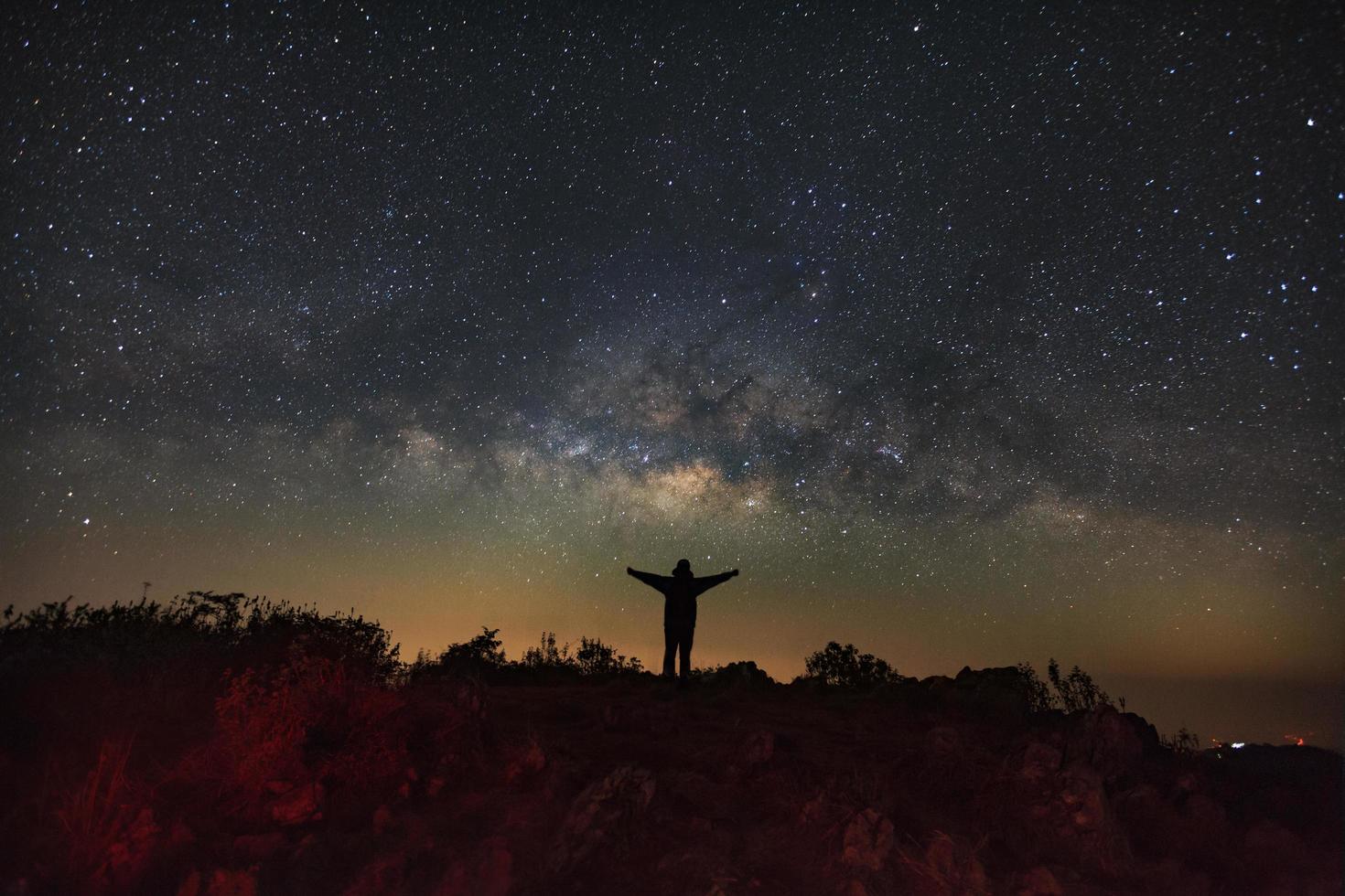 paysage avec voie lactée, ciel nocturne avec étoiles et silhouette d'un homme debout sur la montagne doi luang chiang dao, photographie longue exposition, avec grain photo