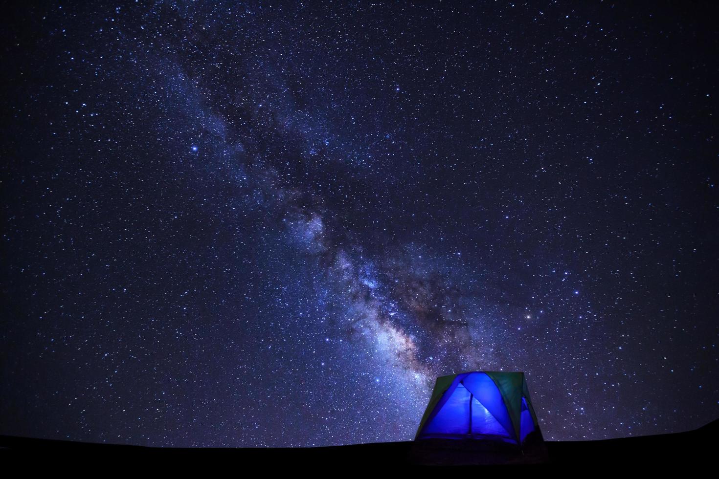 paysage avec voie lactée, ciel étoilé avec étoiles et silhouette de tente dôme photo
