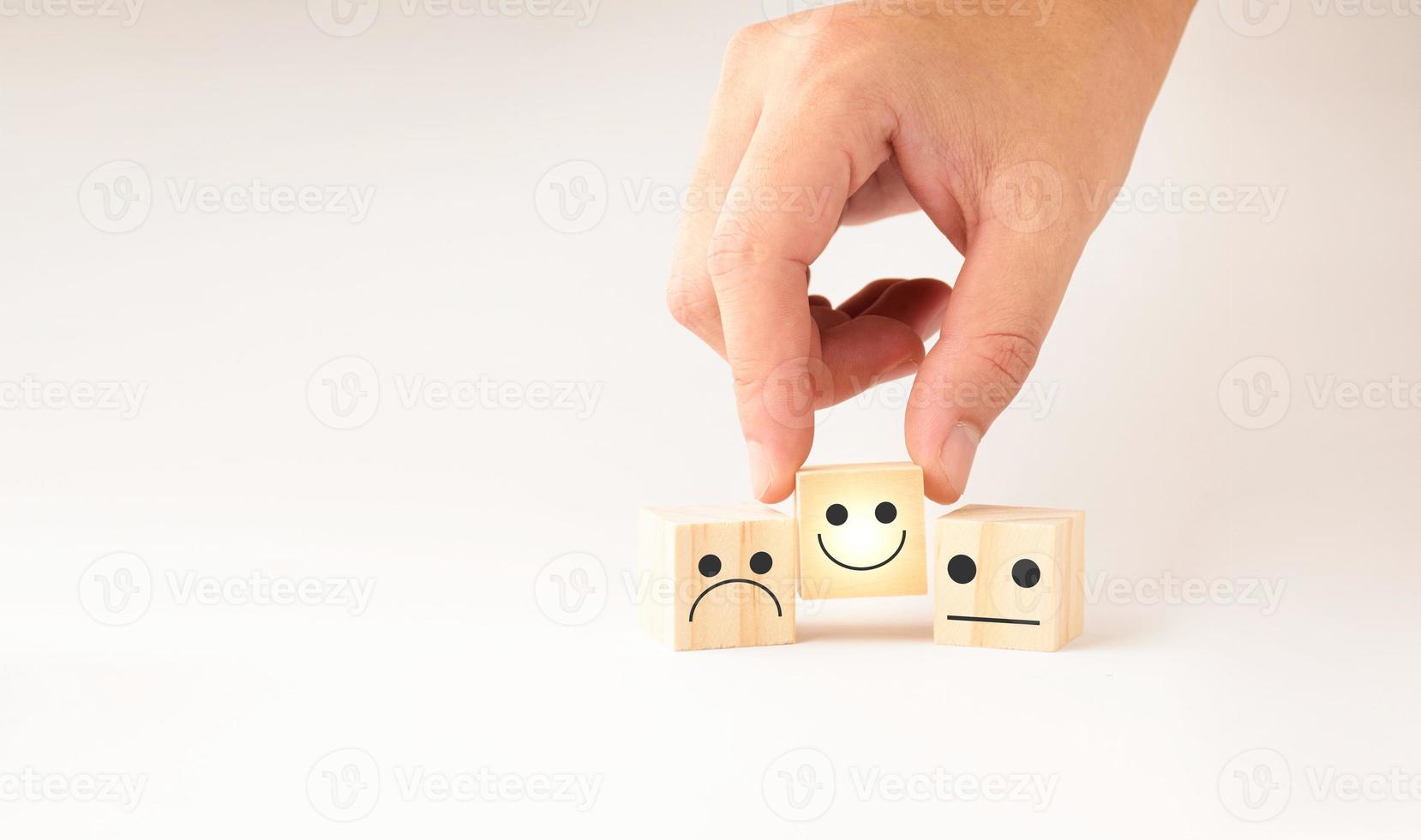 service à la clientèle et concept de satisfaction, les gens d'affaires affichent un retour d'information avec un cube en bois souriant, une icône de visage souriant heureux pour donner satisfaction dans le service. note très impressionné. photo