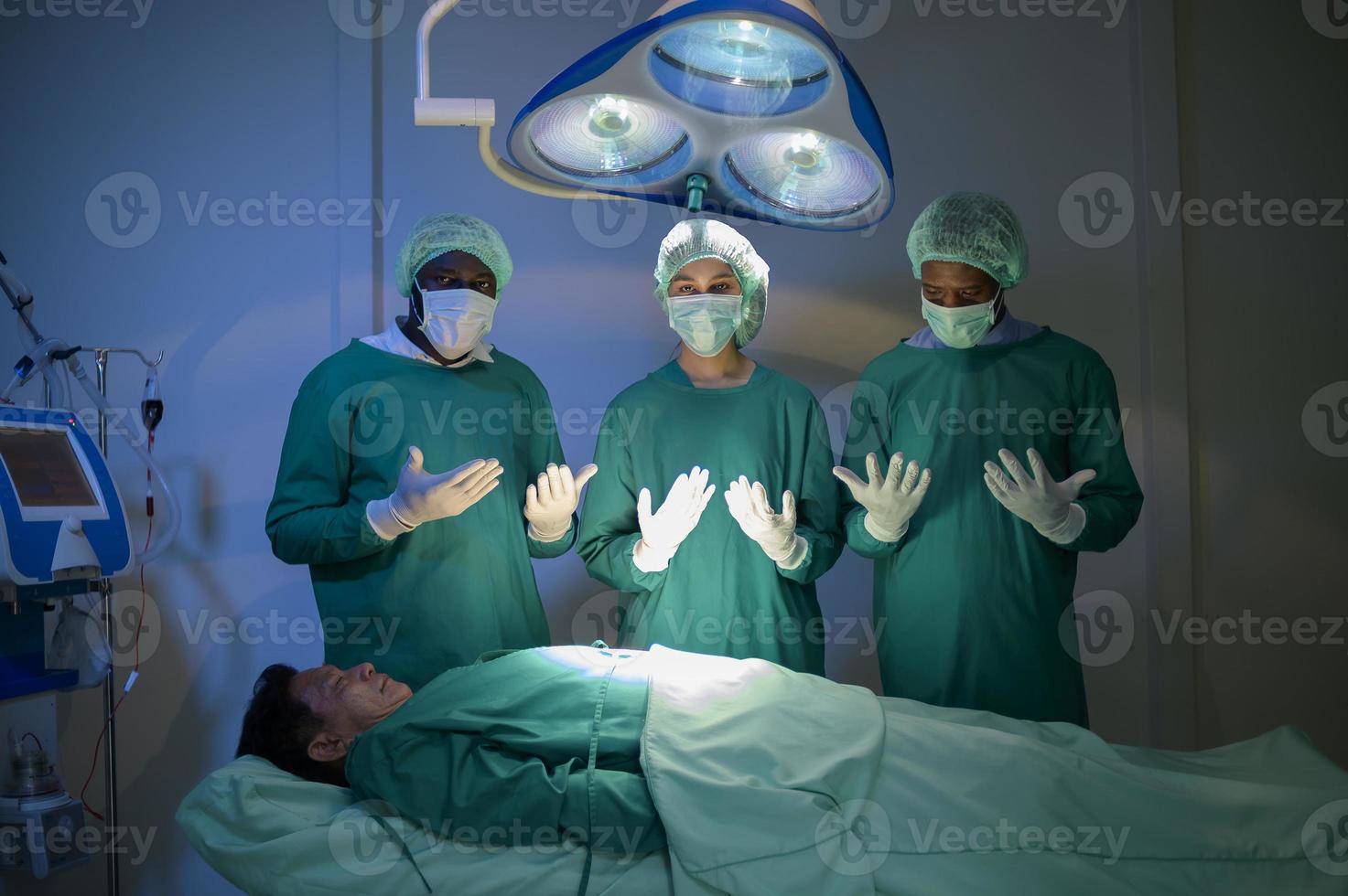 groupe de chirurgiens professionnels métis opérant dans la salle d'opération de l'hôpital, concept de soins de santé. photo