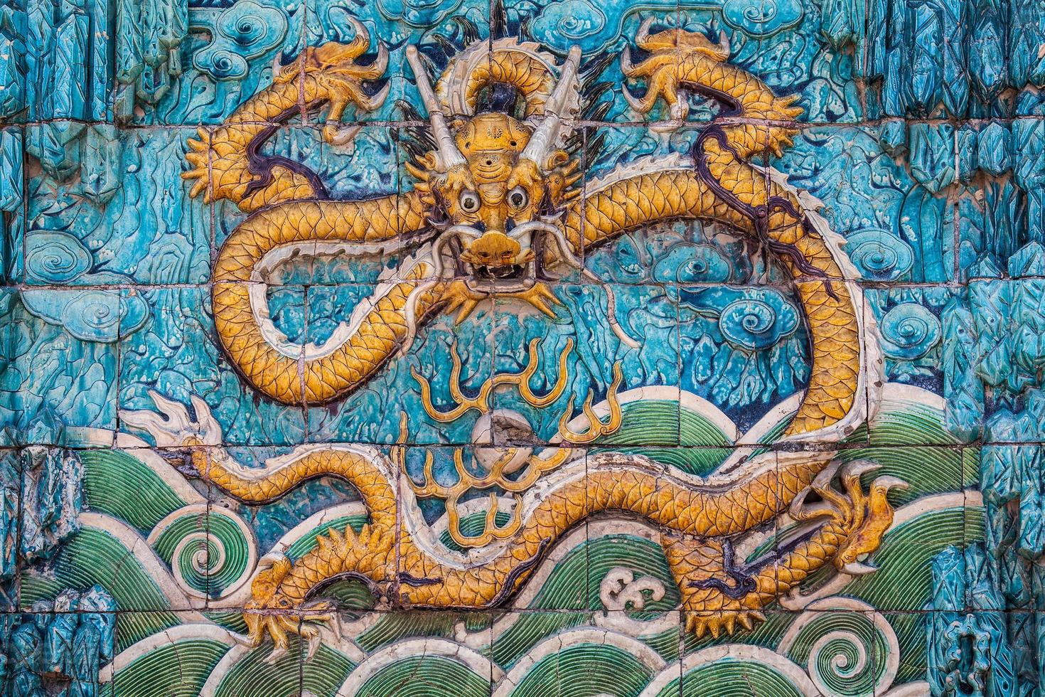 dragon jaune avec des pattes avant surélevées sur le mur photo