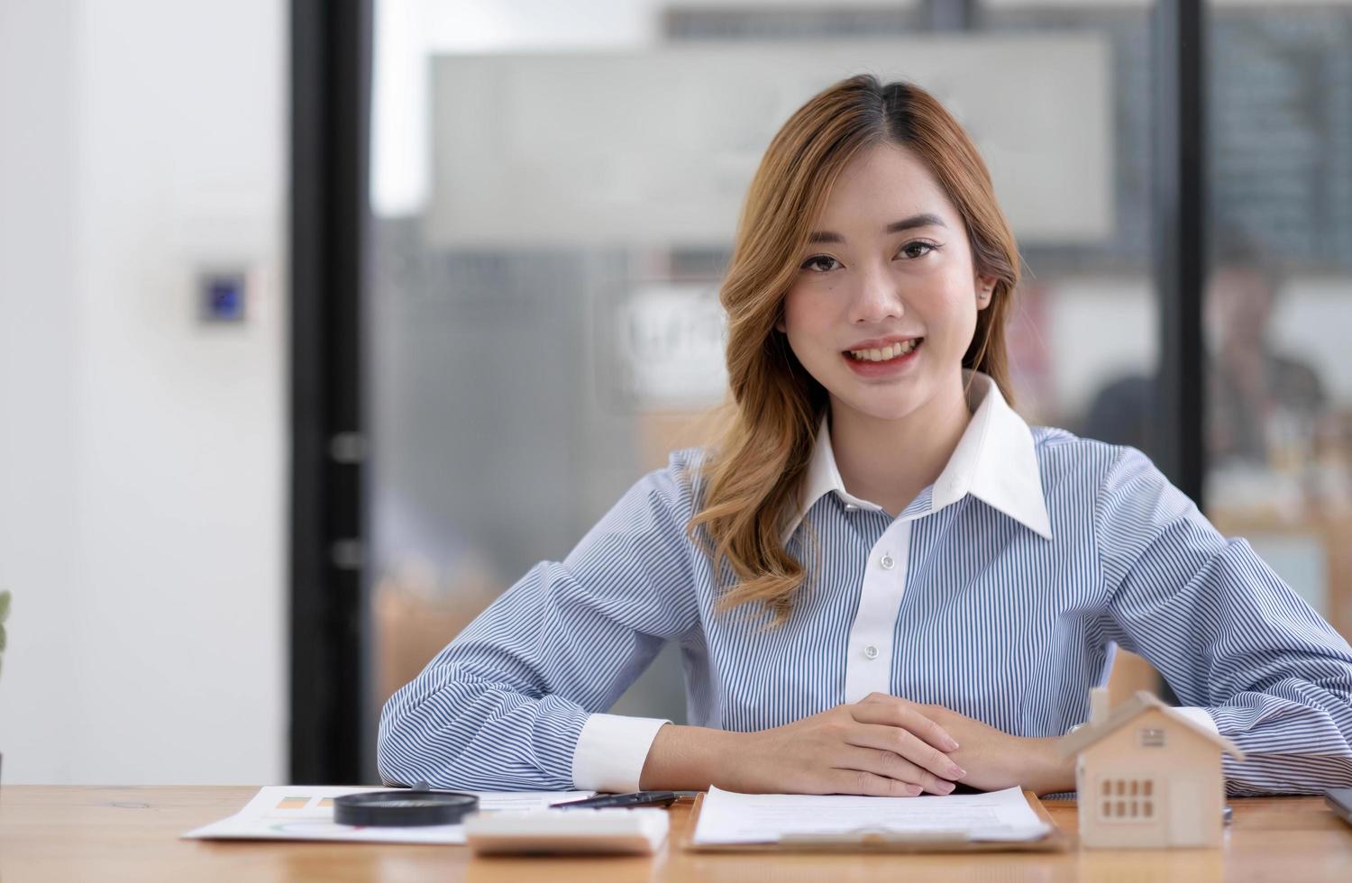 portrait d'une femme d'affaires modèle de maison avec signe un contrat d'achat ou une hypothèque pour une maison, acheter et vendre un modèle de maison, concernant l'offre de prêt hypothécaire pour le concept d'assurance habitation. photo