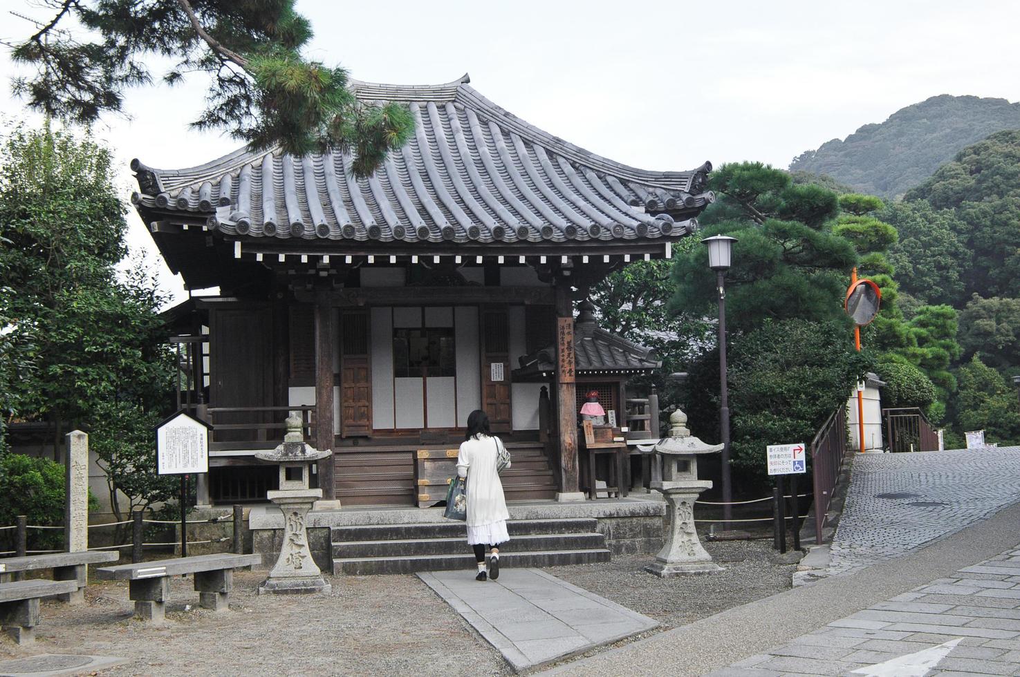 une dame priant à l'ancien petit sanctuaire japonais photo