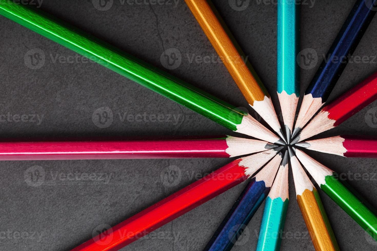 crayons en bois de différentes couleurs en forme d'étoile sur fond noir. photo