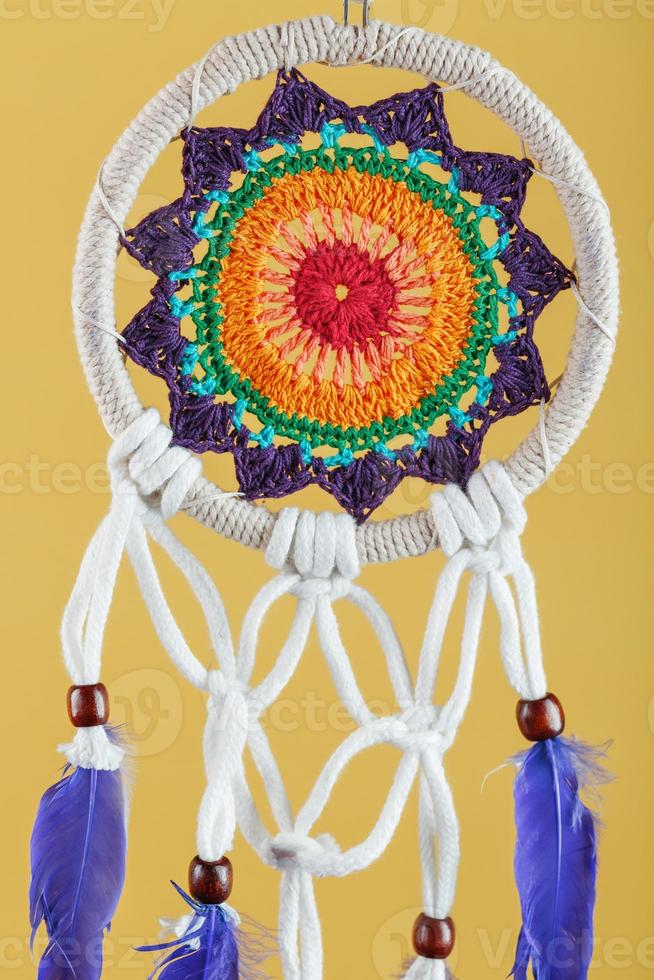 amulette dreamcatcher sur fond jaune close-up protégeant le dormeur photo