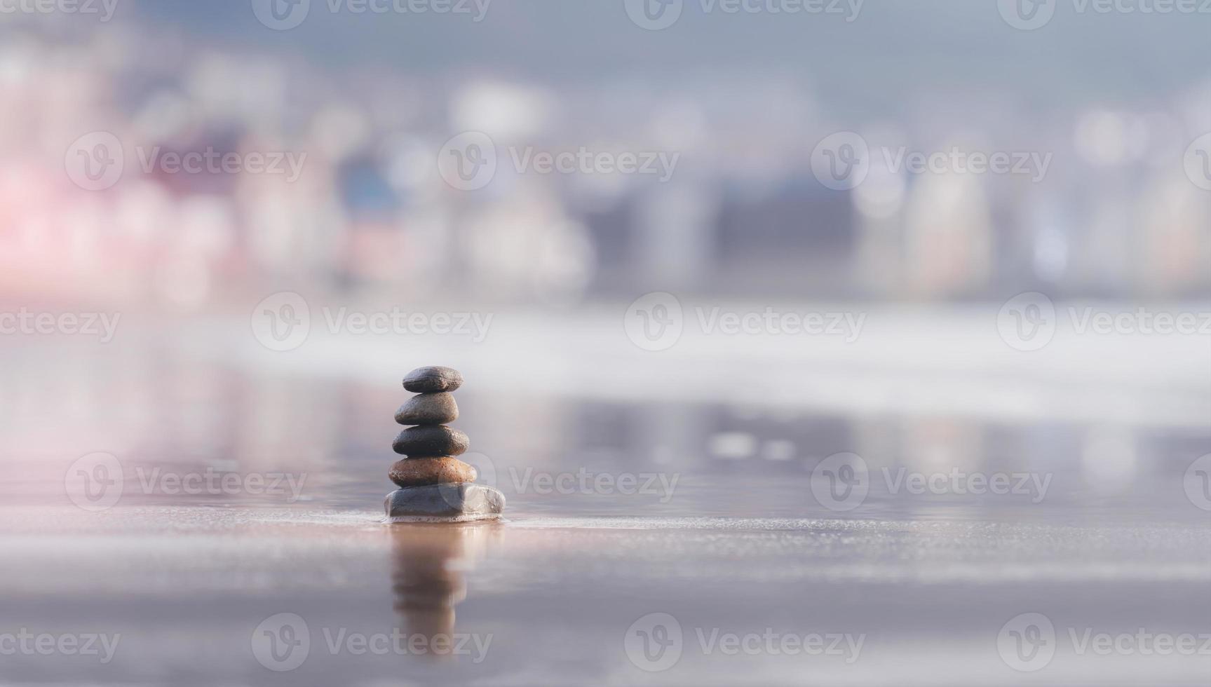 concept zen, tour de galets empilés les uns sur les autres au bord de la mer sur le sable de la plage avec un arrière-plan flou, la pyramide de pierres symbolise, la stabilité, l'harmonie et l'équilibre avec une faible profondeur de champ. photo