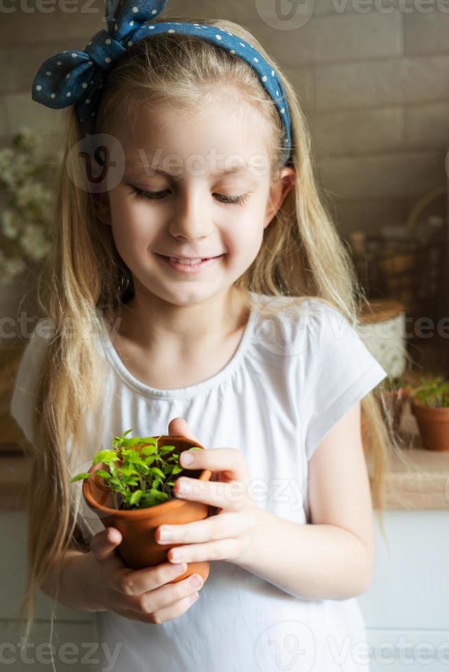 petite fille tenant un pot de semis photo