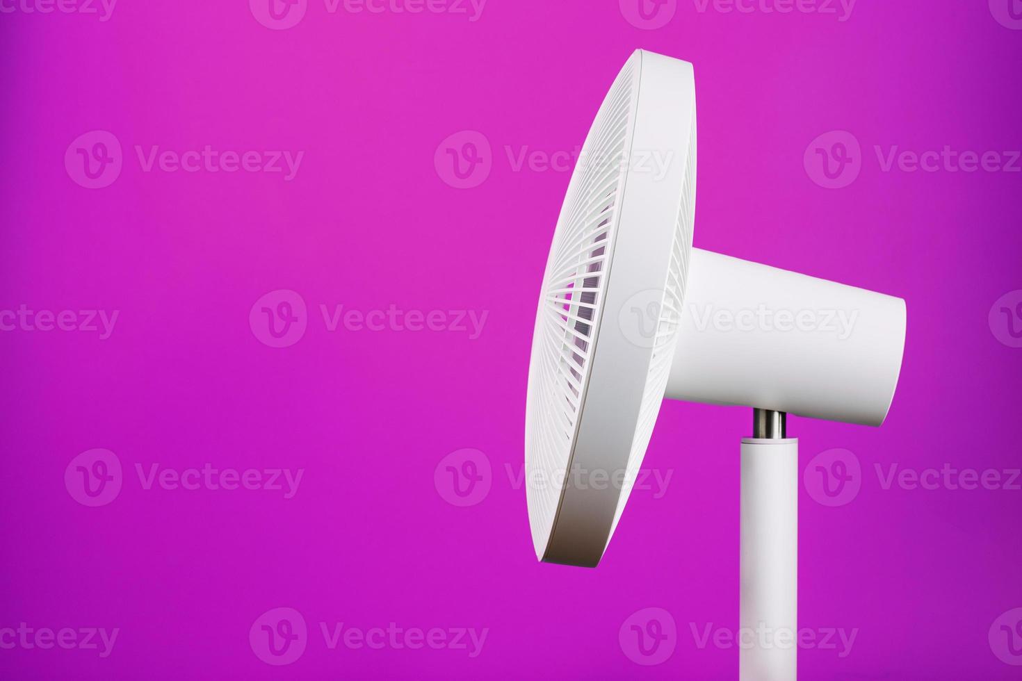 ventilateur électrique blanc au design moderne pour rafraîchir la pièce sur fond rose. photo